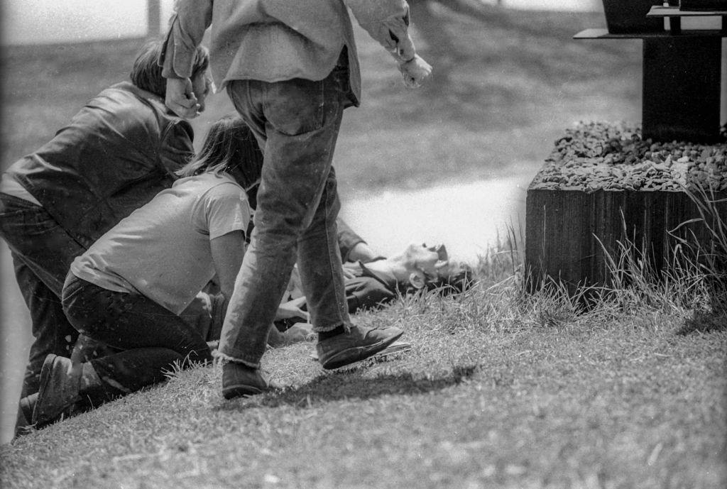 Students kneel on the grass beside wounded classmate John Cleary after the latter had been shot when the Ohio National Guard opened fire on antiwar protesters, Kent, Ohio, May 4, 1970.