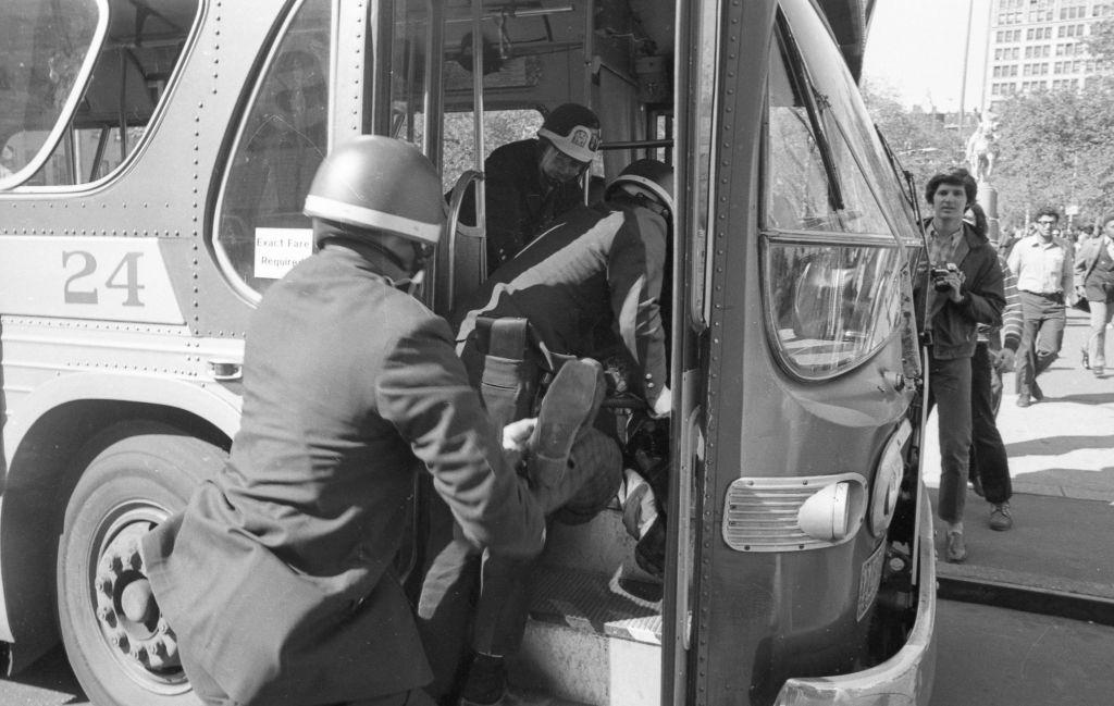 Police carry an arrested protester into a waiting bus, May 7 1970.