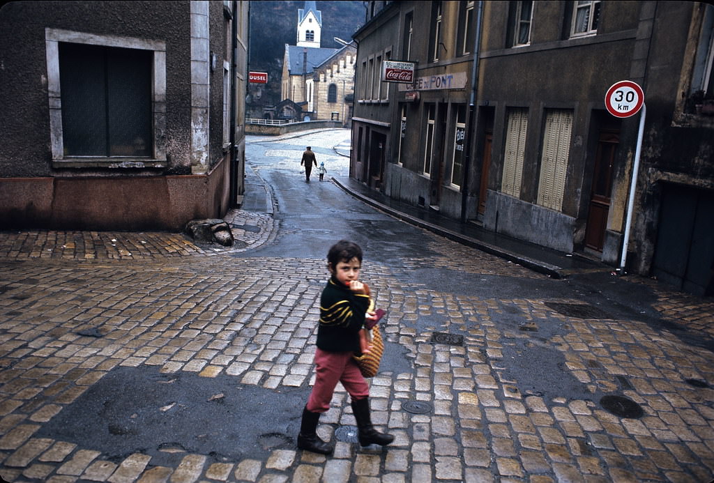 Young boy walking on Rue Mohrfels about to cross Rue du Pont.