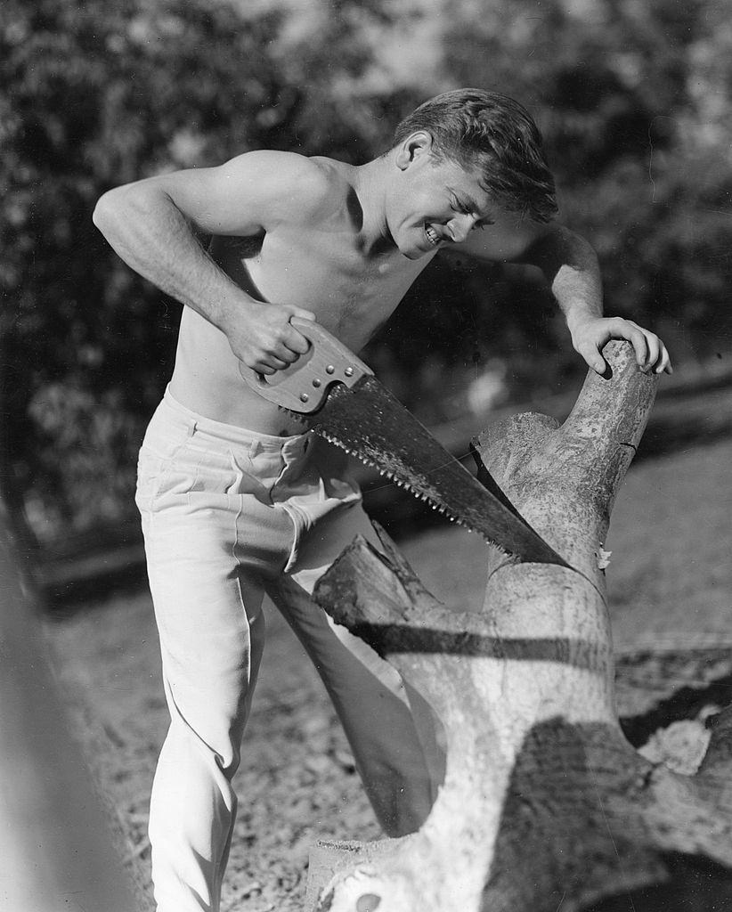 Mickey Rooney cutting a wood, 1930s.