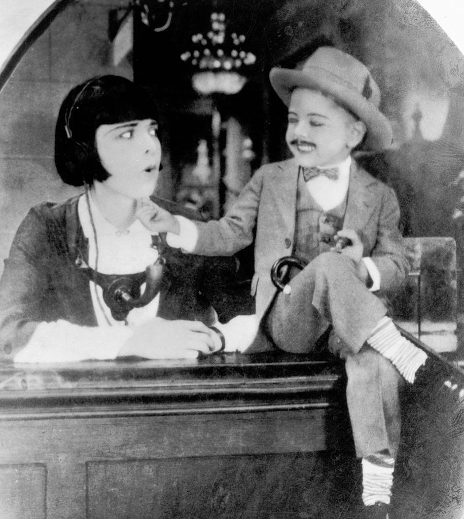 A mustachioed 4-year-old Mickey Rooney tickles his co-stars chin in a silent movie, 1924.