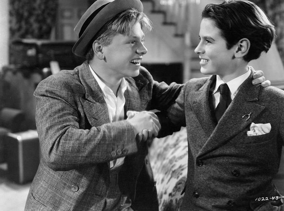 Mickey Rooney shaking Ronald Sinclair's hand in a scene from the film 'Thoroughbreds Don't Cry', 1937.