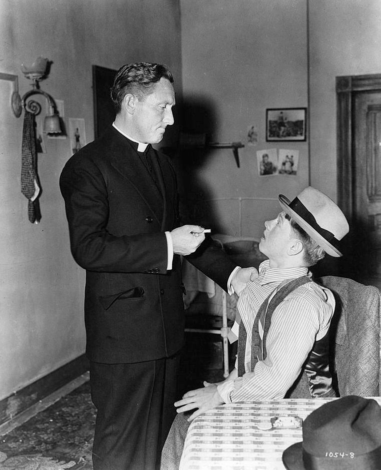 Spencer Tracy disciplines Mickey Rooney for smoking in a scene from the film 'Boys Town', 1938.