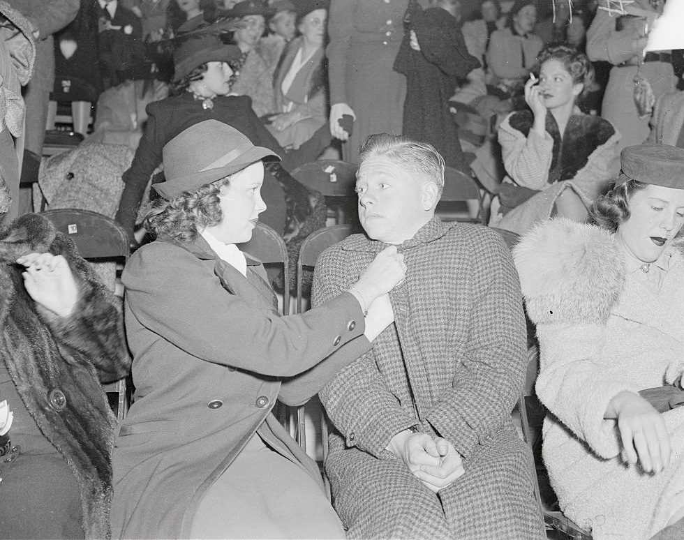 Judy Garland adjusting coat of Mickey Rooney.