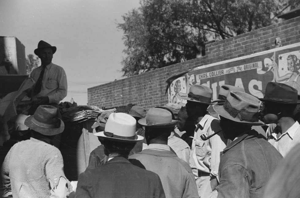 Itinerant salesman selling goods from his truck to workers in center of town on Saturday afternoon. Belzoni, Mississippi Delta. November 1939