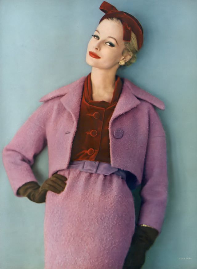 Monique Chevalier in brilliant lilac wool tweed suit worn with a hat and blouse of ruby-red velvet, Vogue. November 1, 1958