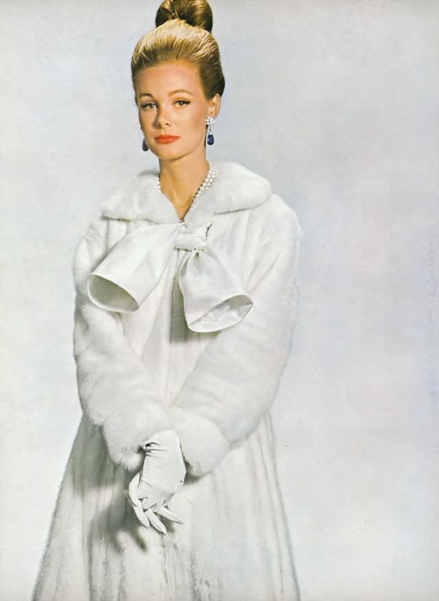 Monique Chevalier in Jasmine EMBA white mink coat-dress, white satin tie and zipped closing in front, Vogue. October 1, 1963.
