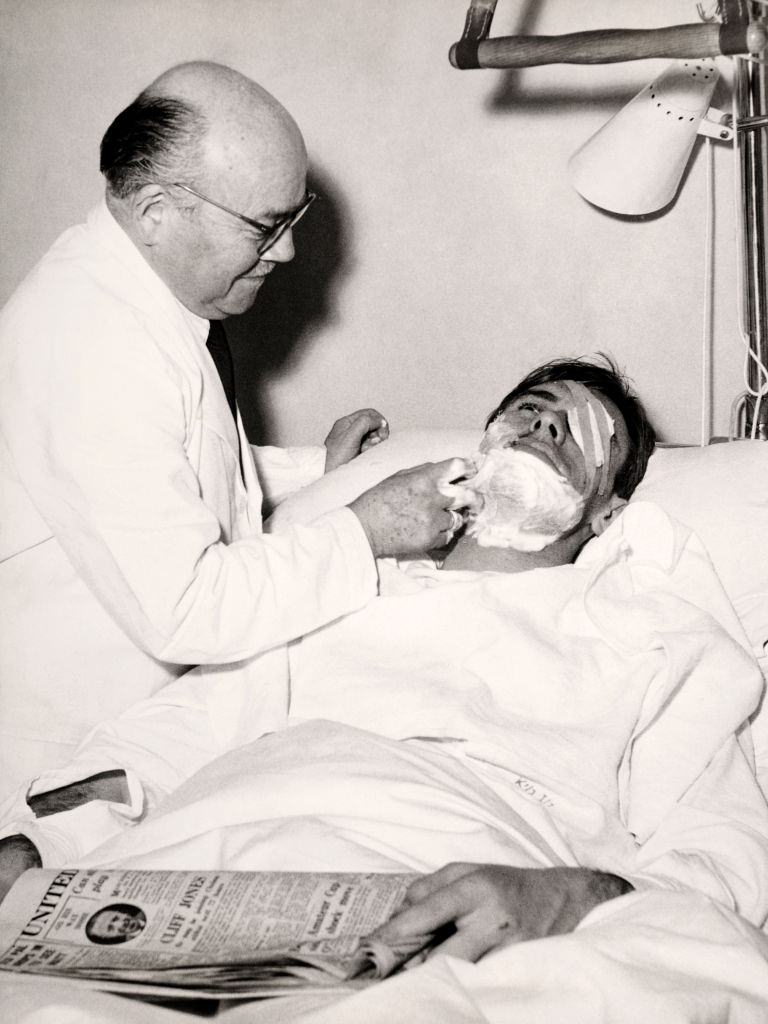 An orderly shaves Manchester United survivor Ray Wood following the Munich Air Disaster. Feb 1958.