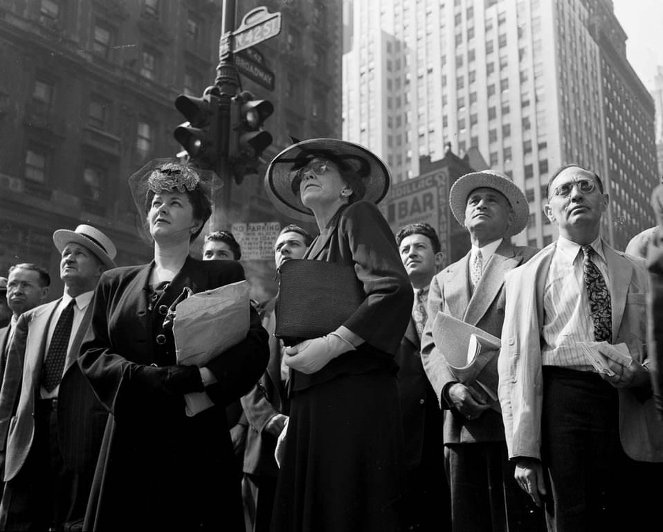 People in Times Square watch the news ticker on the New York Times building.