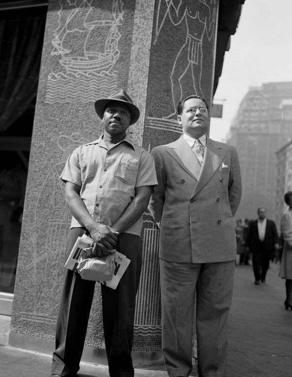 Two men stand tersely on a street corner on the day that news broke.