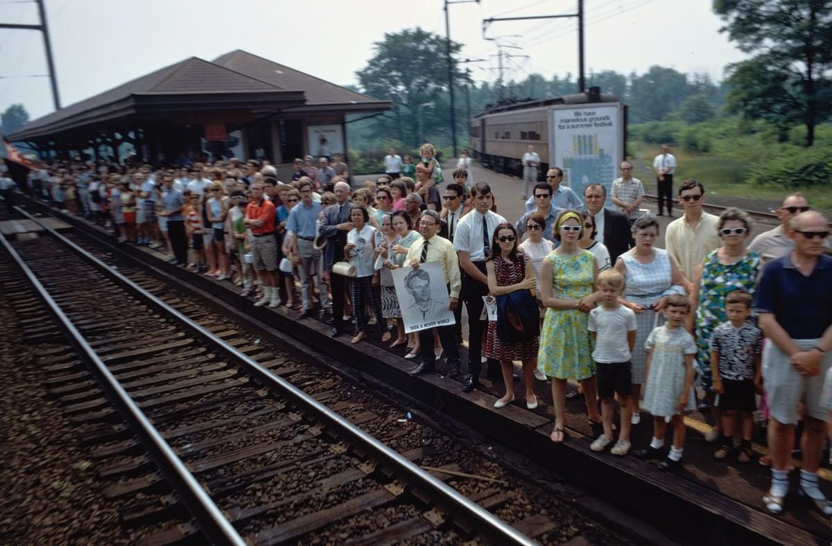 The funeral train rolls through Princeton Junction, New Jersey, on June 8, 1968. Several people hold portraits of Robert F. Kennedy, including a man whose poster reads Seek a Newer World.