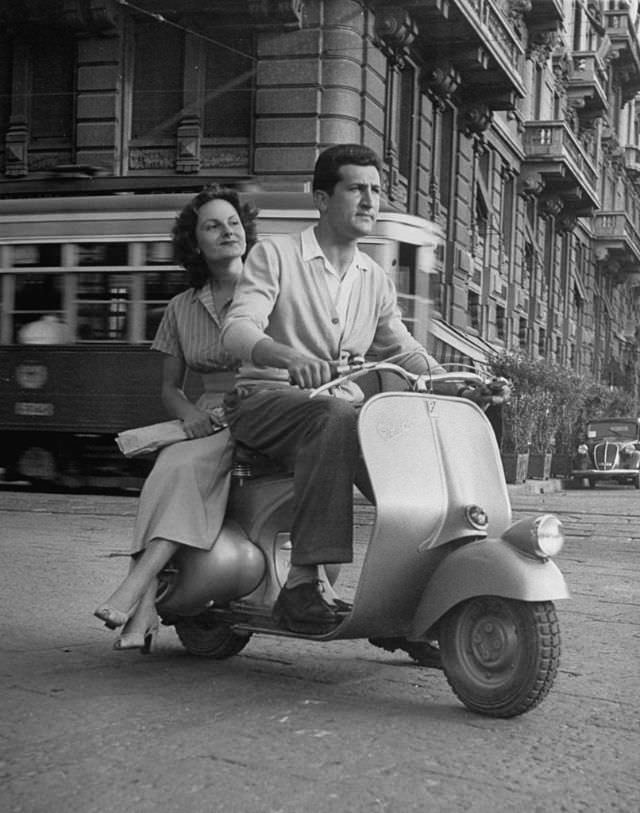 A man and a woman on a Vespa.