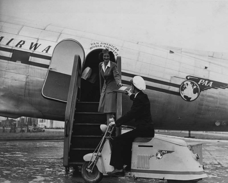 An airport messenger delivers a package to a stewardess.