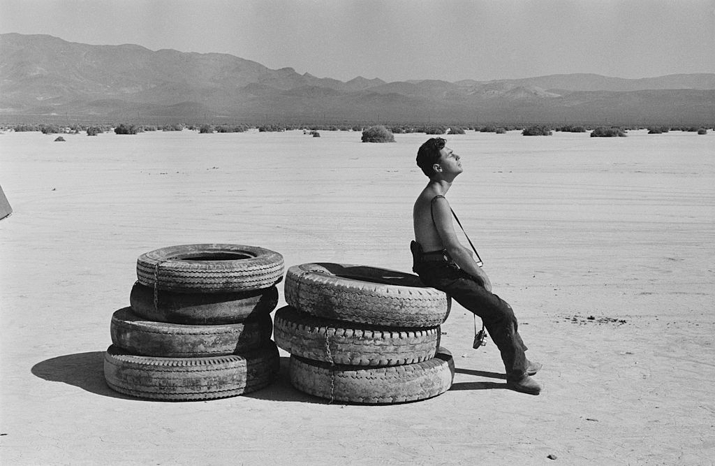 Magnum photographer Elliott Erwitt resting in the sun during the filming of 'The Misfits' on location in the Nevada Desert.