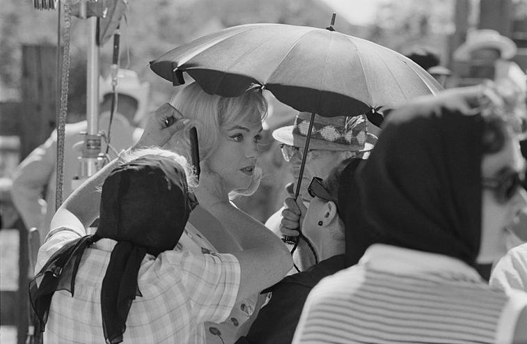 Marilyn Monroe is surrounded by attentive women on the set of John Huston's 'The Misfits'