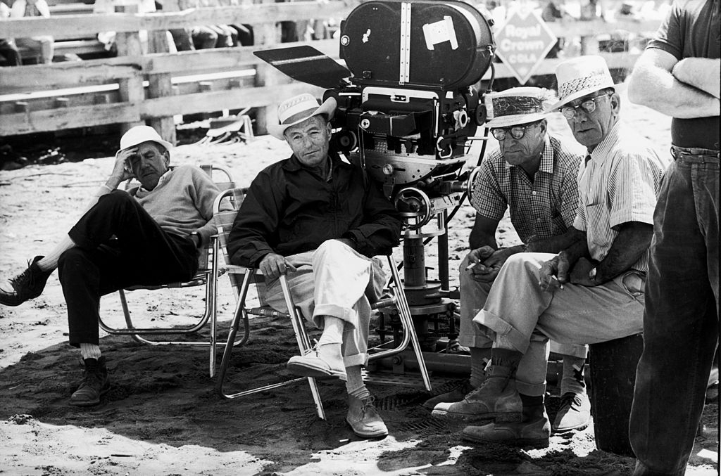 A group of crew members resting in the shade on the set of John Huston's 'The Misfits'