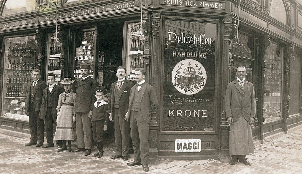 Delicatessen salesmen with his employees in front of his delicatessen shop entitled "Zur goldenen Krone" in Vienna, 1900.