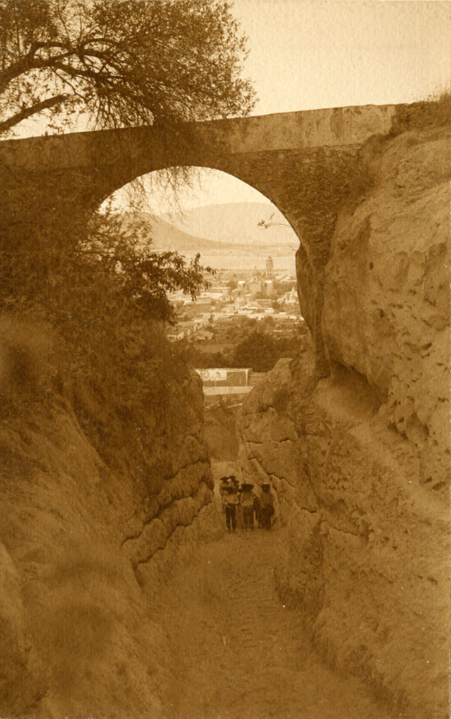Men standing under stone archway Atlixco. Puebla, 1907