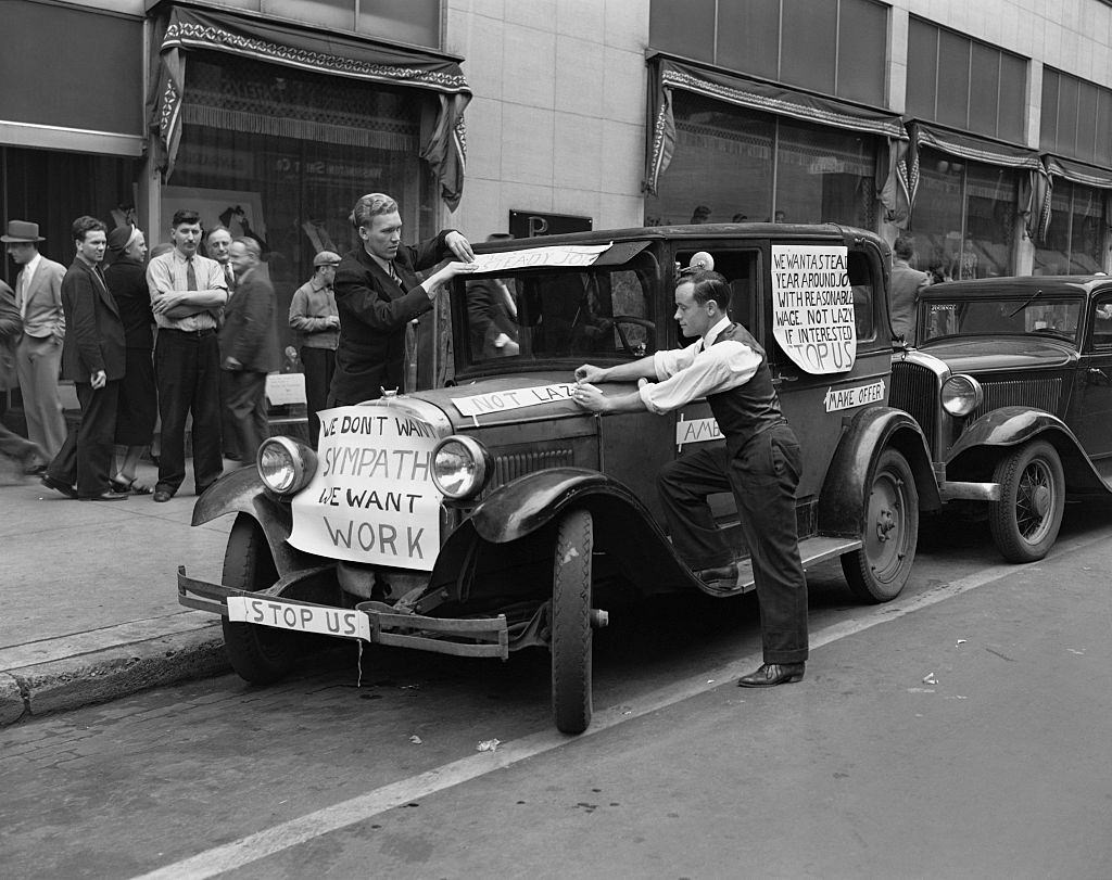 Job seekers during the Great Depression have put signs on their car expressing their wish to work. Minneapolis, 1930.