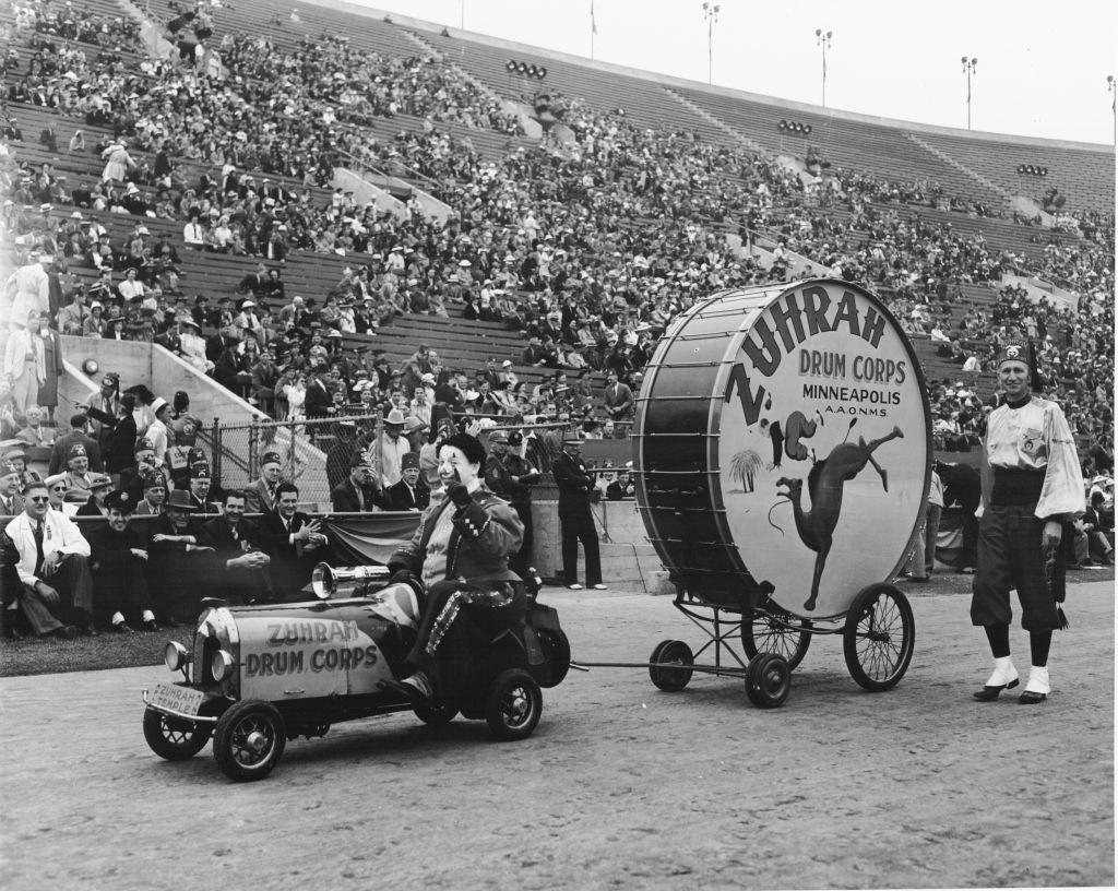 Shriner's parade inside Coliseum featuring clown and drum from Zuhrah Drum Corps. Minneapolis, Minnesota, 1930.
