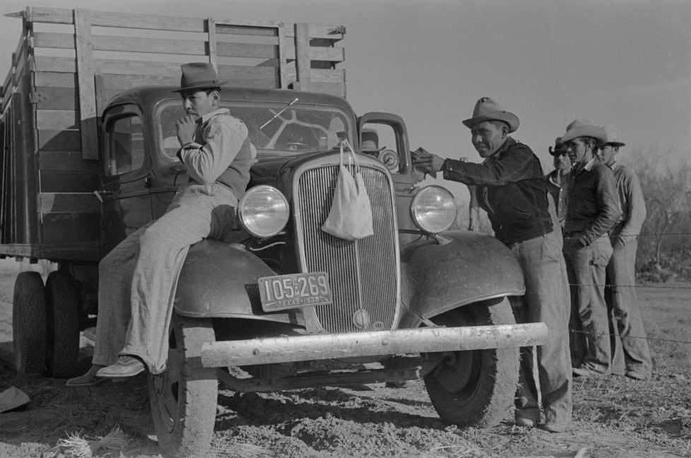 Mexican carrot workers around labor contractor's truck in field near Santa Maria, Texas, February 1939.