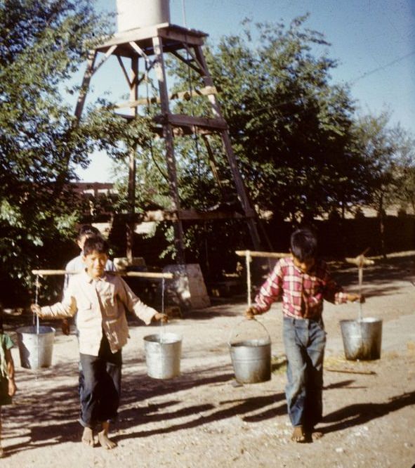 Two young boys carrying water for the hospital, Cuauhtemoc, 1950s