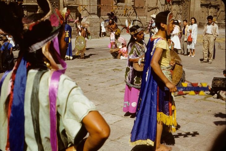 Indians in regalia, preparing for performance in plaza, 1950s