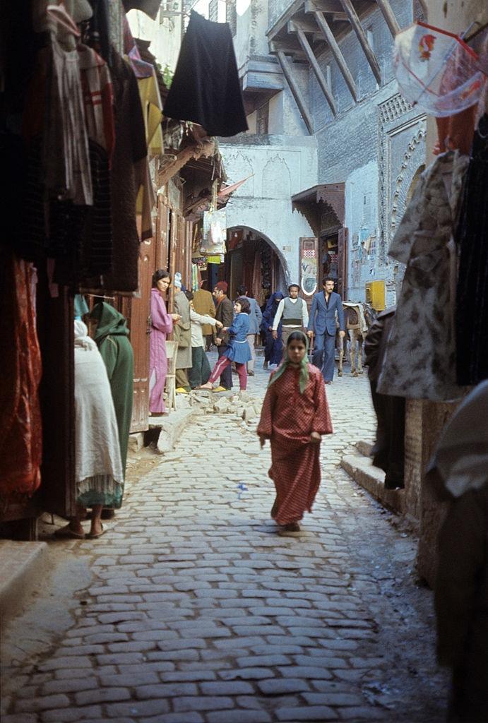 Girl walking down a city street. Marrakech, 1960.
