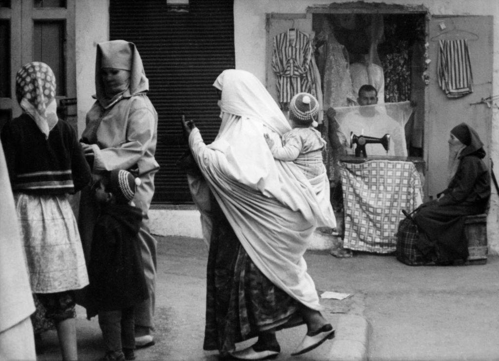 Women in the street pass by a tailor's workshop in the Medina on April 6, 1968 in Rabat, Morocco.