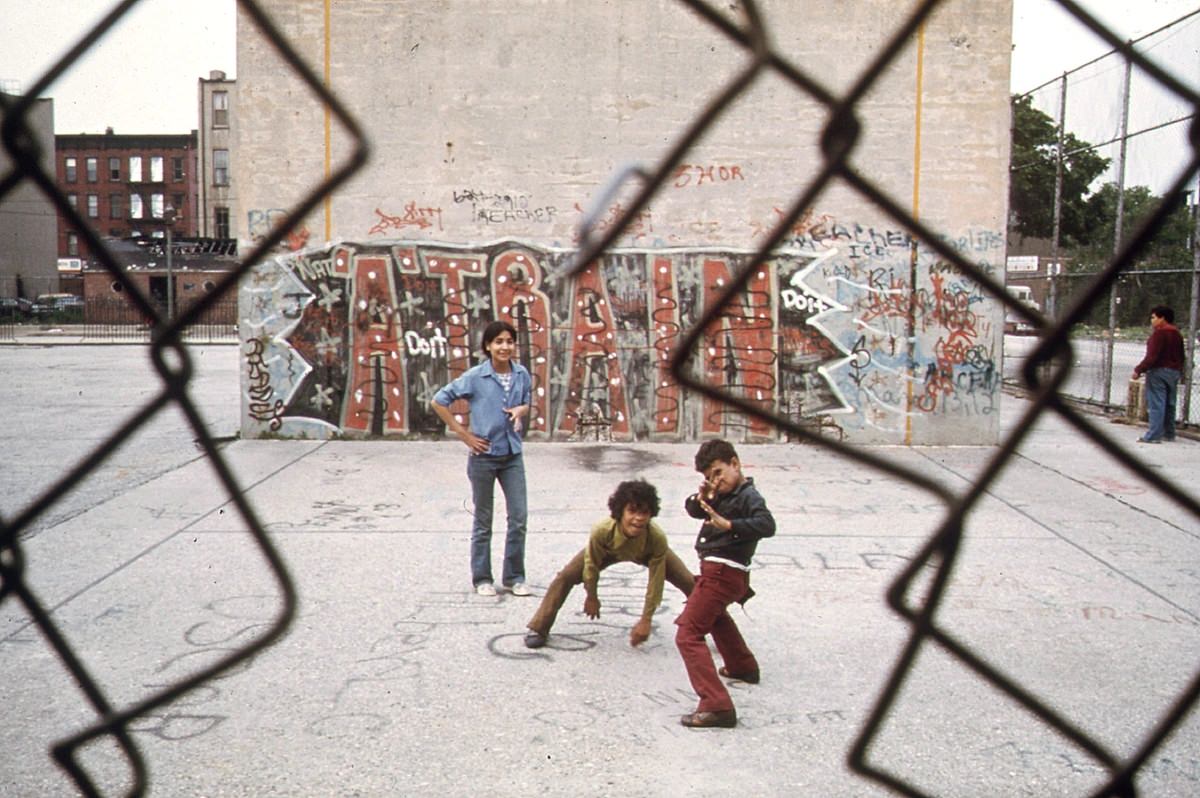 Children play in front of "A Train" graffiti in Brooklyn's Lynch Park, in June of 1974.