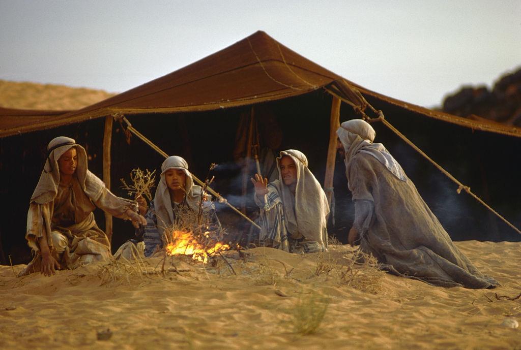 Berber boys sit around a fire by a tent in Morocco, 1971.