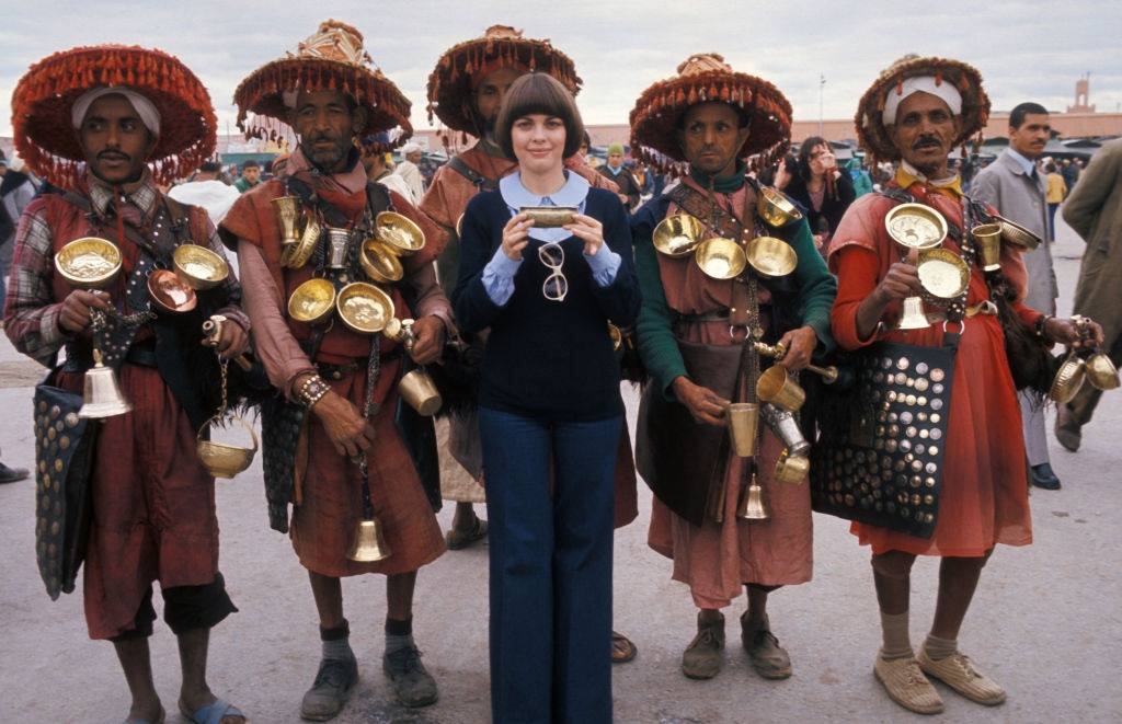 Mireille Mathieu surrounded by men in traditional dress in May 1976 in Morocco.
