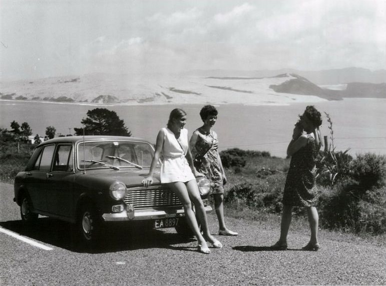 Women with their a rental car stop on Omapere Hill for a photograph of Hokianga Harbour, Northland, August 1970