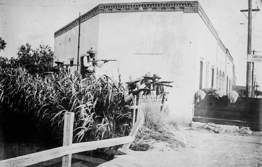 Rebels take up firing positions near an irrigation ditch.