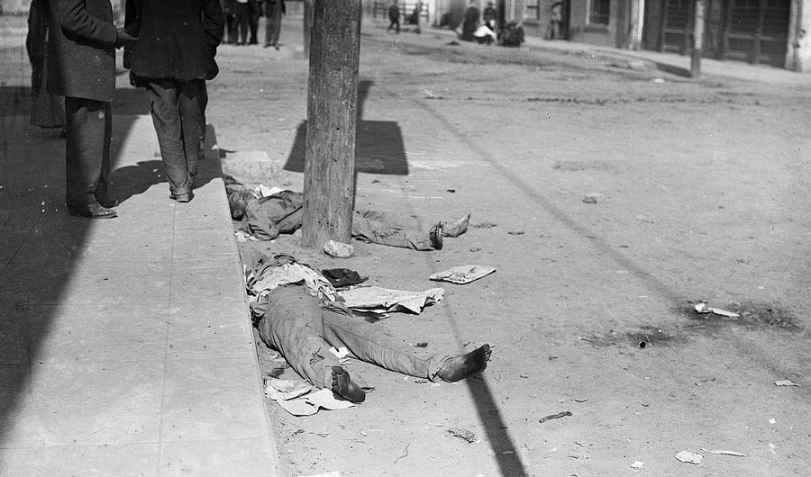 Bodies are shown lying in the street after battle.
