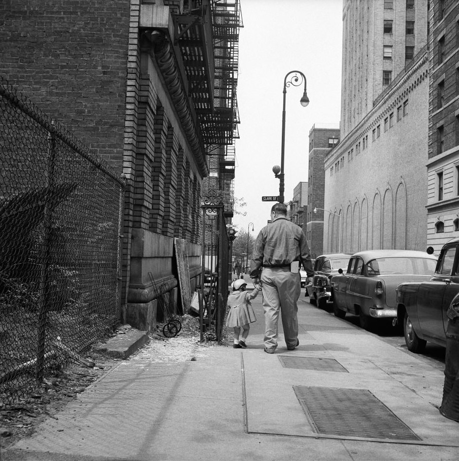 A father and daughter walk near Clark Street in Brooklyn Heights, March 1958.