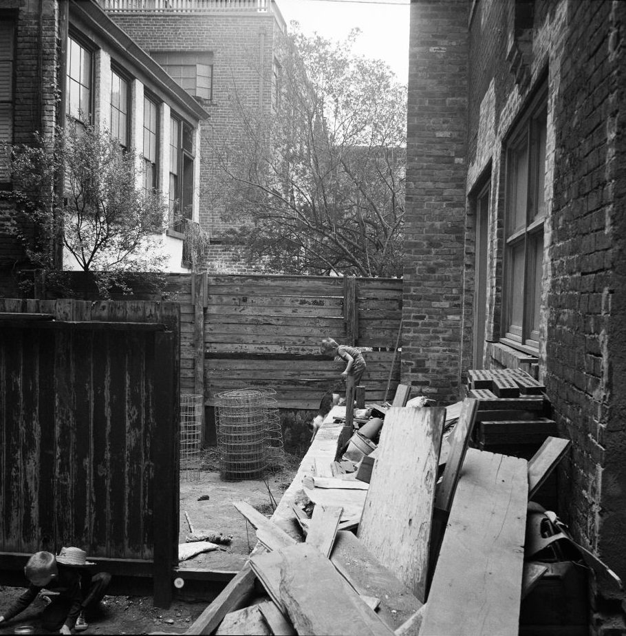 Children play with construction materials in an alleyway in Brooklyn Heights, March 1958.