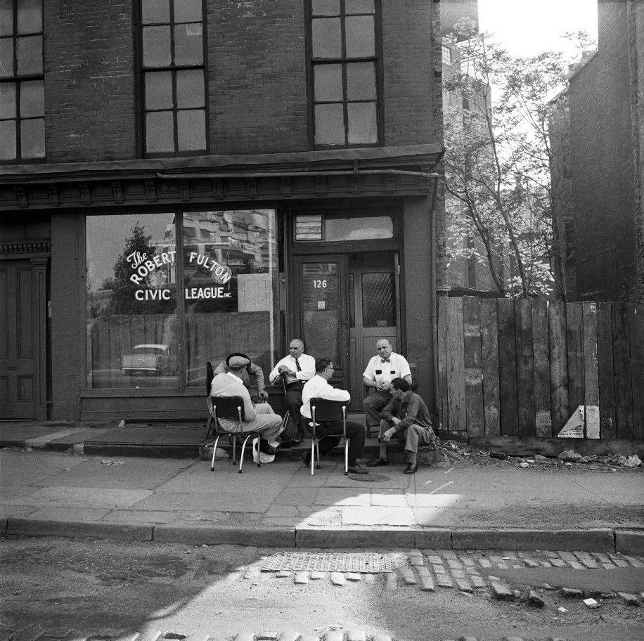 Men socialize outside the Robert Fulton Civic League in Brooklyn Heights, March 1958.