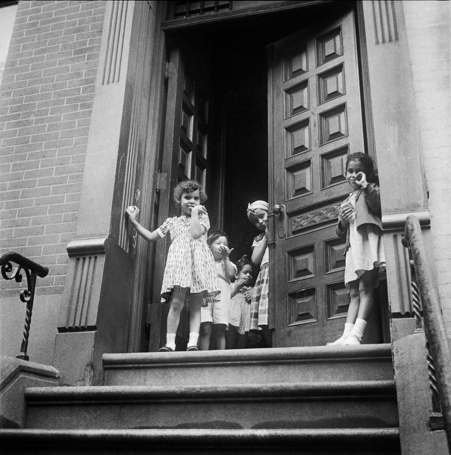 Young girls stand on a stoop in Brooklyn Heights, March 1958.