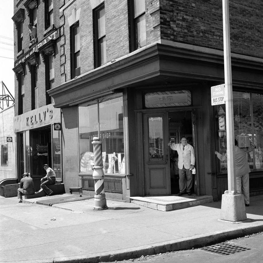 Barber Jerry talks to a delivery man outside Jerry's Barber Shop, at 15 Atlantic Avenue in Brooklyn Heights, March 1958.