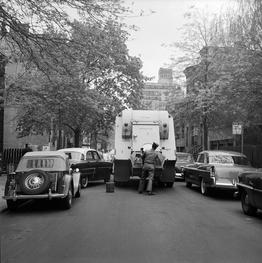 A sanitation worker collects garbage in Brooklyn Heights, 1958.