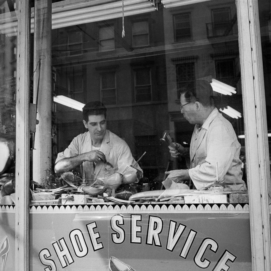 Two cobblers work inside a shoe repair store in Brooklyn Heights, March 1958.