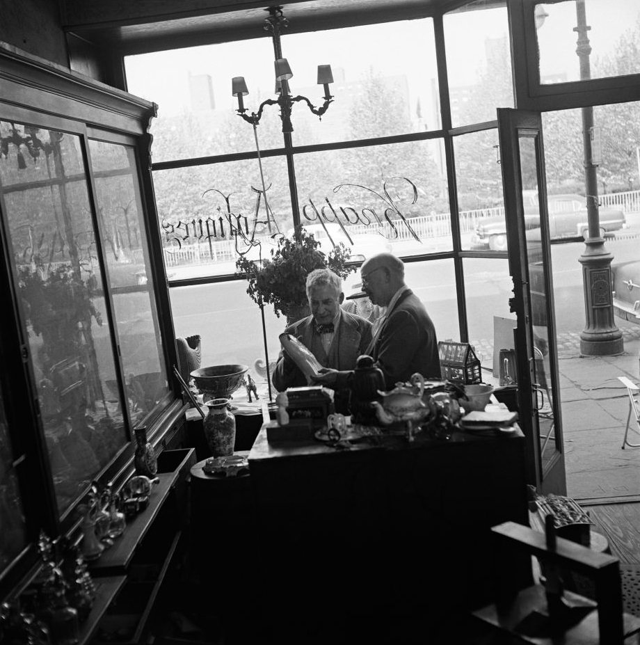 Legendary antiques dealer George Knapp, a subject of author Truman Capote, helps a customer at Knapp Antiques, at 224 Fulton Street in Brooklyn Heights, March 1958.