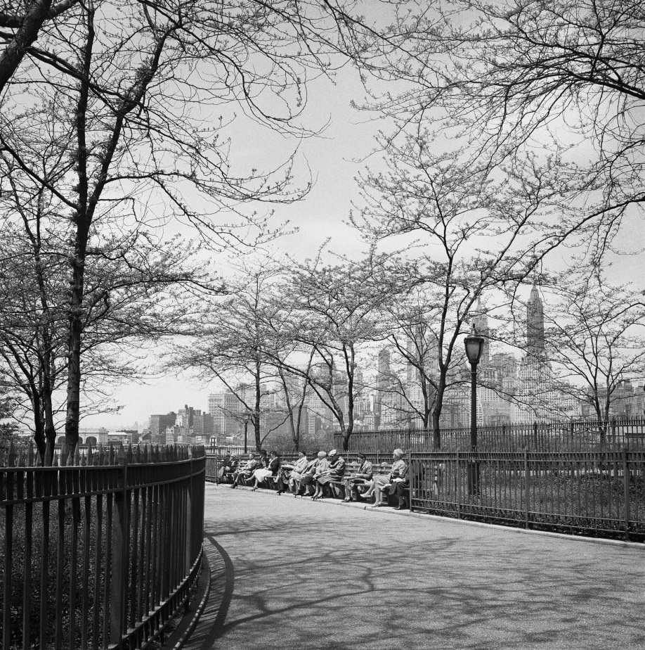 People sit on the Brooklyn Heights Promenade, with a view of the Manhattan skyline, in Brooklyn Heights, March 1958.