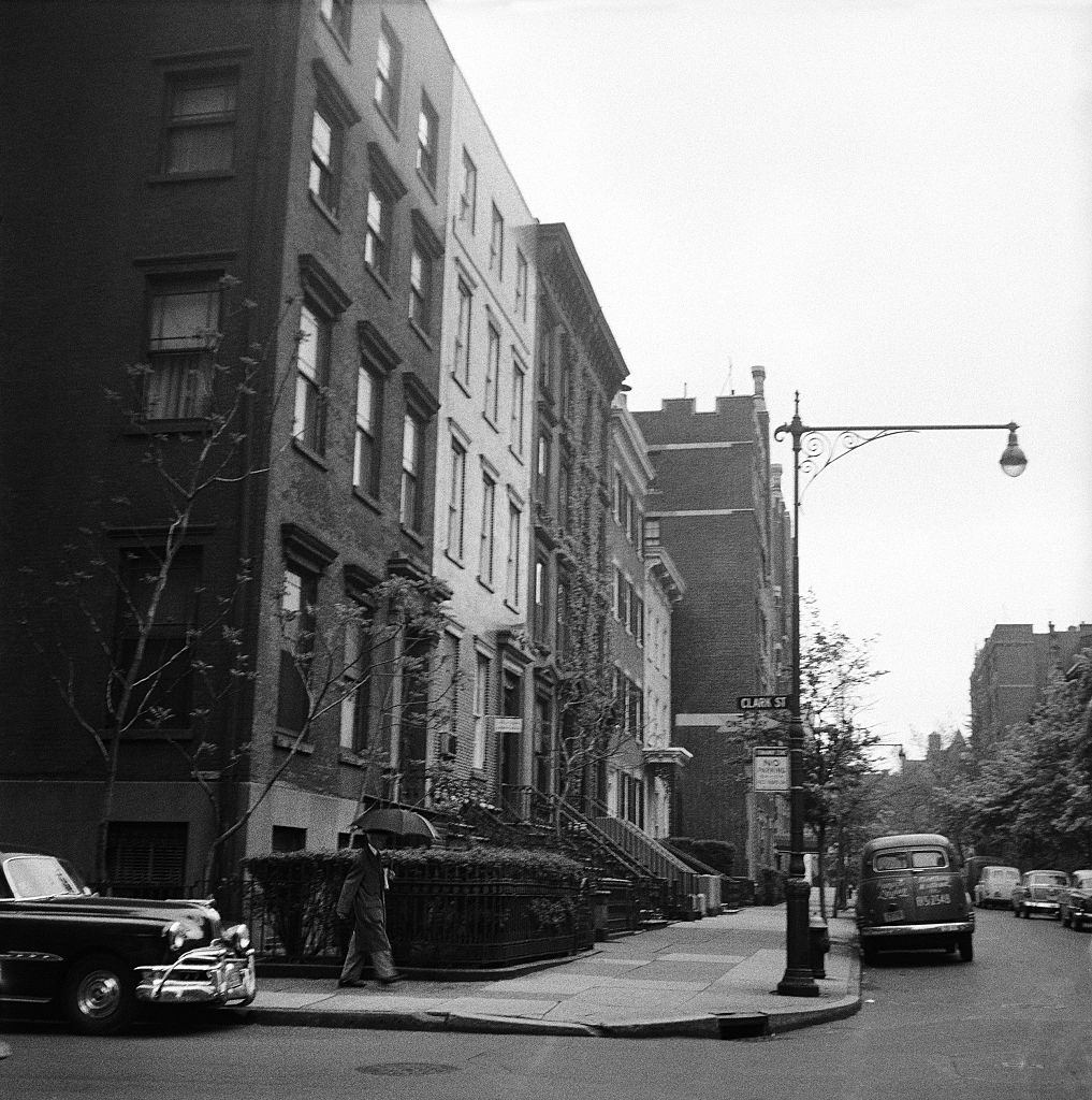 A a man walks in the rain on Clark Street in Brooklyn Heights, March 1958.