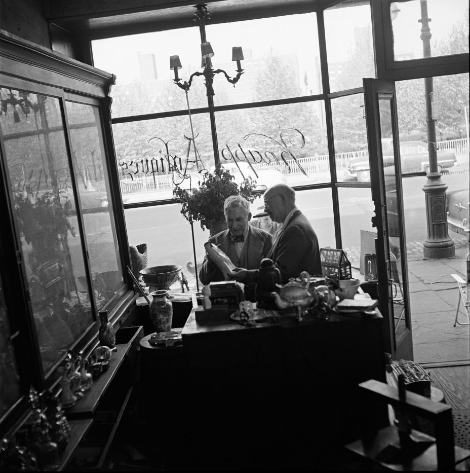 Legendary antiques dealer George Knapp, a subject of author Truman Capote, helps a customer at Knapp Antiques, at 224 Fulton Street in Brooklyn Heights, March 1958.