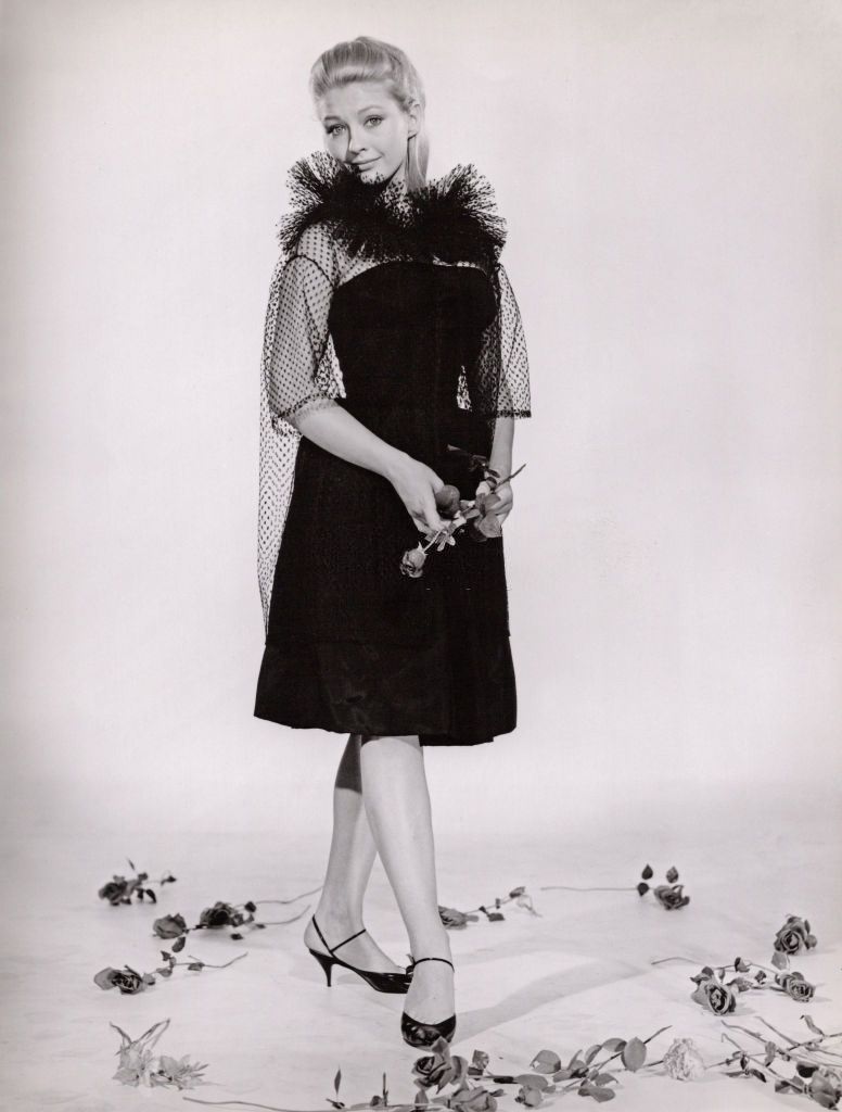 Christine Kaufmann in black dress holding a rose, 1961.