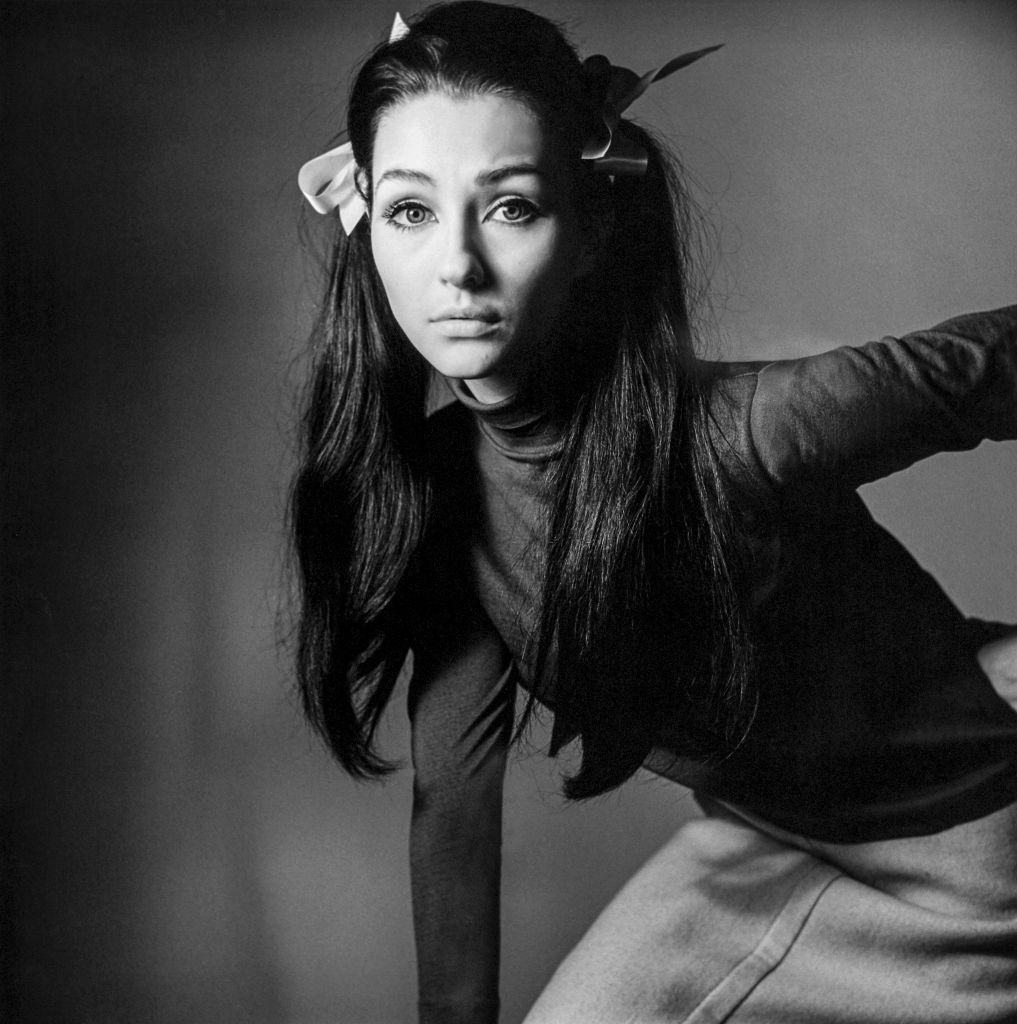 Christine Kaufmann wearing dark turtleneck and light skirt.