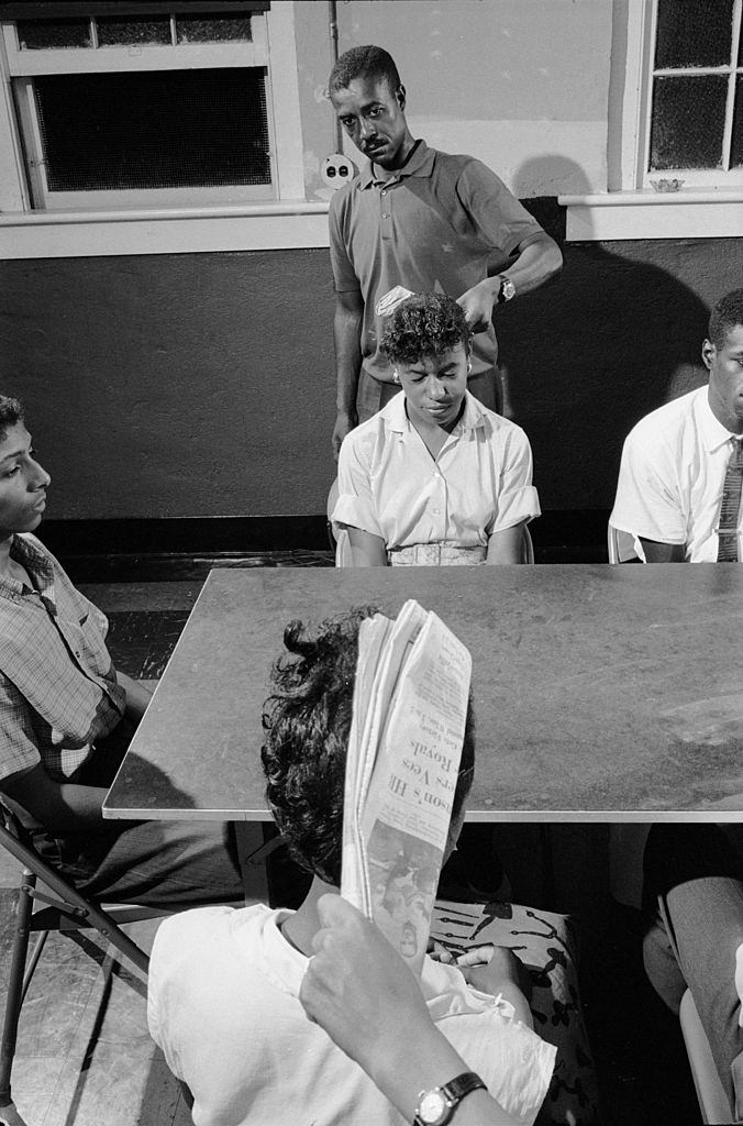 Trainers use newspaper to swat the heads of volunteers to prepare them for some of the types of harassment that they will likely encounter, 1960.