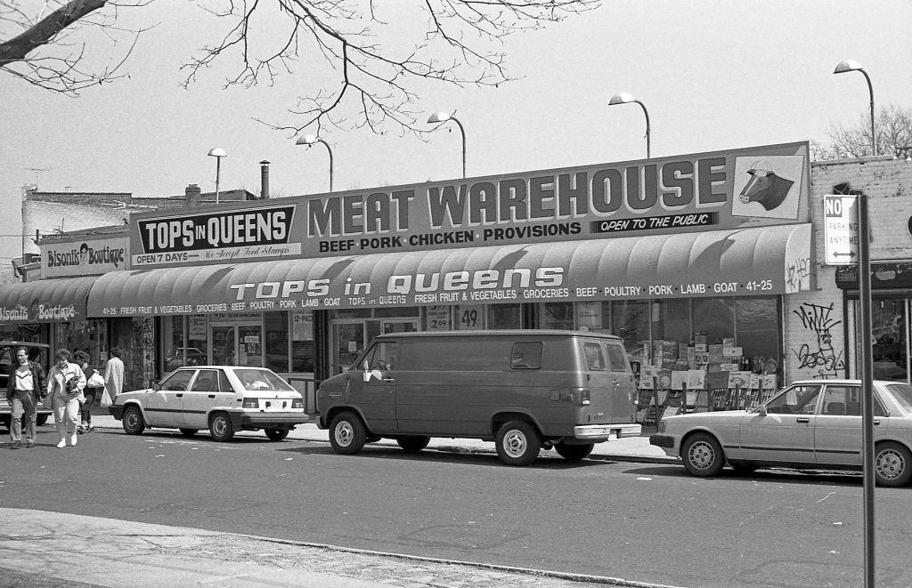 Veteran's Square park (at the intersection of 102nd and National streets with 42nd Avenue) of various businesses along 102nd street, in the Corona neighborhood. Queens, New York, 1990.